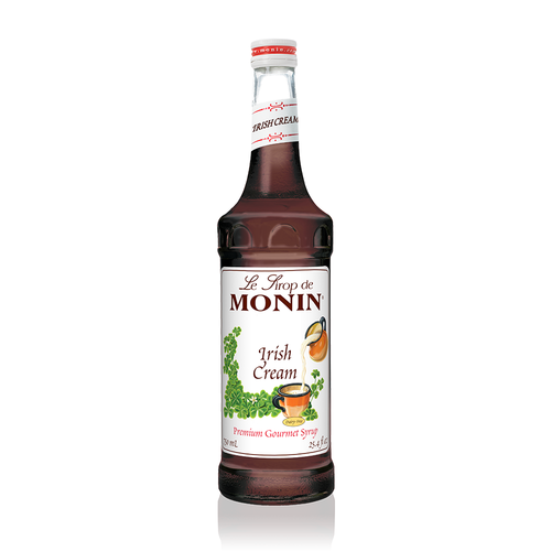 A 750 mL (25.4 fl oz) glass bottle of Monin Irish Cream Premium Gourmet Syrup. The syrup is a dark, translucent brown color. The white label features the Monin logo and illustrations of a pitcher pouring cream into a mug, surrounded by green shamrocks. The label includes the text "Irish Cream," "Dairy-Free," and "Premium Gourmet Syrup."