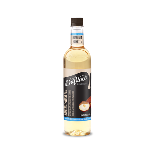 A 25.4 FL OZ (750 mL) glass bottle of DaVinci Gourmet Sugar Free Hazelnut Syrup. The clear bottle contains light golden syrup with a dark cap and a light blue neck band reading "Hazelnut / Noisette". Its black main label features white script branding above vertical text reading "Hazelnut / Noisette," a light blue bottom strip reading "Sugar Free Syrup / Sirop Sans Sucre," and an illustration of whole and shelled hazelnuts.