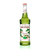 A 750 mL (25.4 fl oz) bottle of Monin Pistachio Premium Gourmet Syrup. The light green syrup is visible through the bottle, which features a white label with the Monin logo and botanical illustrations of pistachio nuts in their shells and green leaves. The label includes the text "Pistachio" and "Premium Gourmet Syrup."