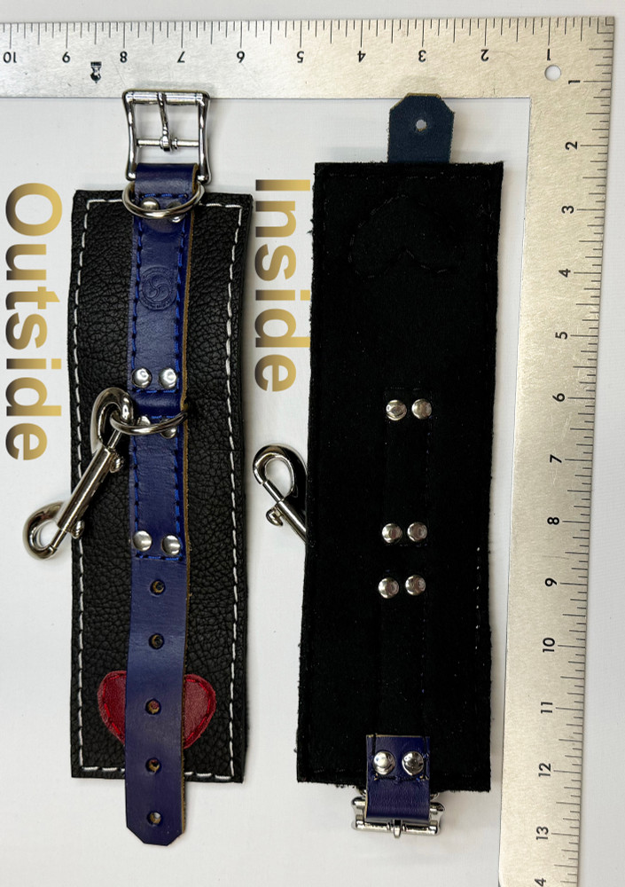 PRIDE blue on black cuffs, with a red leather heart on one end underneath the blue piece, front and back, shown with a ruler to show the size.