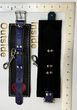 Pride blue on black cuffs, with a red leather heart on one end underneath the blue piece, front and back, shown with a ruler to show the size.