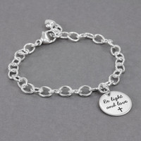 Side view of custom Your Saying On A Bracelet in sterling silver, personalized with message "Be Light and Love" stamped on the charm