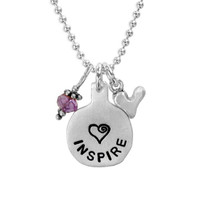 Silver necklace hand stamped with the word Inspire and a heart, with a birthstone and a silver heart charm hung on a silver chain, shown close up