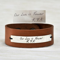 Light brown leather handwriting cuff, shown with handwritten message engraved on silver plate