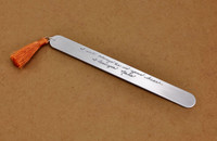 Custom bookmark personalized with your actual handwriting, with an orange tassel, shown on brown background from the side