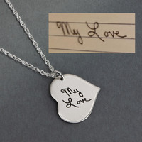 Custom silver Handwriting heart necklace, personalized with the words, "My Love", and hung from the side. Shown on gray paper with the original handwritten note. With an image like this, we clean up the blur and the perspective distortion, and remove the lines. 