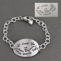 Grandkids' writing engraved on large silver oval handwriting bracelet as a gift for Grandma. Shown with actual handwriting used to personalize the bracelet