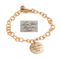 Custom memorial gold charm bracelet, engraved with note in father's handwriting & his signature, with gold puffed heart by the clasp, shown on white with original handwriting used to personalize the bracelet