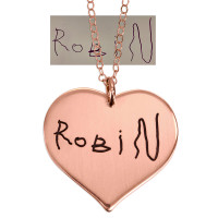 Handwriting heart necklace in rose gold engraved with child's signature to make a mother's day gift, shown with original handwritten note from whiteboard used to personalize it