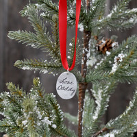 View hung on a tree of the back of custom handwriting memorial Cross Ornament, personalized with late father's actual handwritten signature engraved on a fine pewter oval, hung on a red ribbon