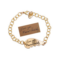 Gold memorial handwriting angel wing bracelet, personalized with your loved ones actual handwriting, showing the original handwritten note, shown on white