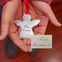 Handwriting Angel Ornament in fine pewter, shown with original handwriting used to personalize it, with red ribbon,  shown in hands