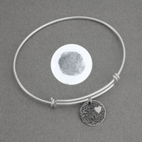 Expandable sterling silver bracelet with custom fingerprint pendant, shown with original fingerprint used to personalize it