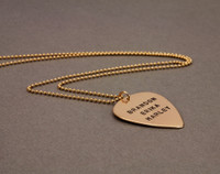 hand stamped personalized guitar pick necklace in gold, shown from the side
