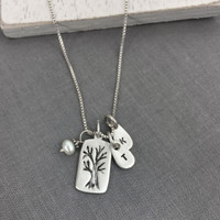 Top view of custom fine silver Family Tree necklace, personalized with hand stamped kids' initials, hung with pearl charm