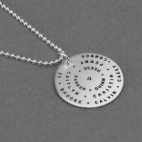 Custom hand stamped silver mother's Love Circle necklace with names in tiny font, shown from the side