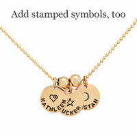 Hand stamped custom Gold Name Discs necklace personalized with kids names and symbols, shown close up on white