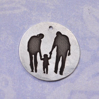 Custom sterling silver circle charm engraved with silhouette of two parents holding the hand of their child