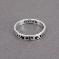 Hand stamped sterling silver stackable rings, personalized with child's name and hearts, shown from the side