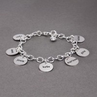 Side view of hand stamped sterling silver custom bracelet for Grandma, stamped with 6 kids' names on circle charms, with a silver puffed heart charm