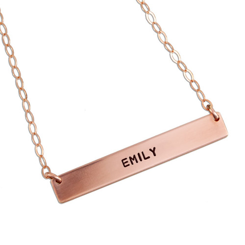 Custom rose gold bar necklace, personalized with hand stamped daughter's name "Emily", shown on white