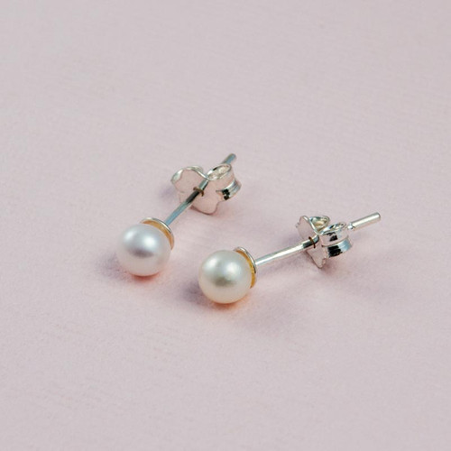 Freshwater Cultured Pearl Stud Earrings, shown close up on pink background