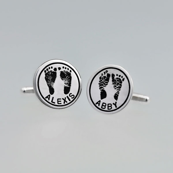 Sterling silver personalized cuff links with your kid's hand prints or footprints, shown on a gray background, with Alexis and Abby names hand stamped on them