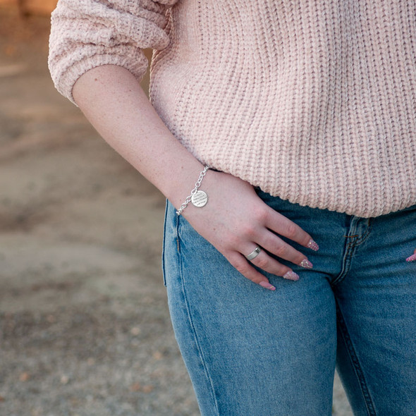 Custom Your Saying On A Bracelet in sterling silver, personalized with your message hand stamped on the charm, shown on a model