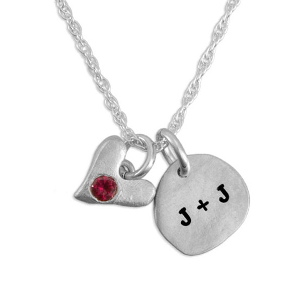 Close up image of Sculpted Nugget round fine silver charm personalized with initials with fine silver handmade heart with embedded birthstone on white background