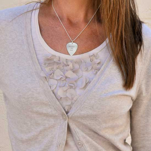 Personalized guitar pick as a necklace, shown on a female model
