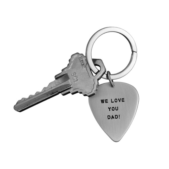 Sterling silver hand stamped guitar pick key chain shown with key on white background