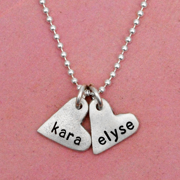 handcrafted silver heart charm necklace, hand stamped with names, shown up close