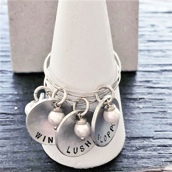 Custom hand stamped wine glass charms in sterling silver personalized with names or words