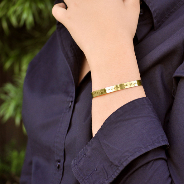 Model wearing custom gold handwriting cuff memorial bracelet with the handwritten note from loved one
