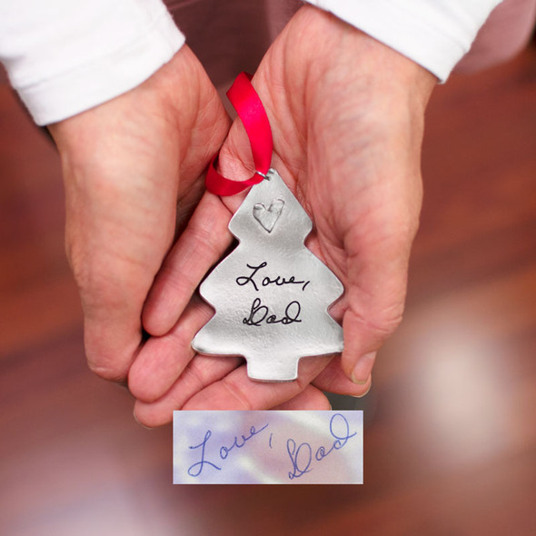 Personalized Christmas Tree Handwriting Ornament in fine pewter, customized with your loved one's handwritten note, shown in hands with original handwritten note