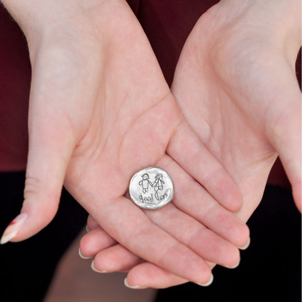 Model holding personalized pocket token with handwriting & artwork on a fine pewter pocket charm