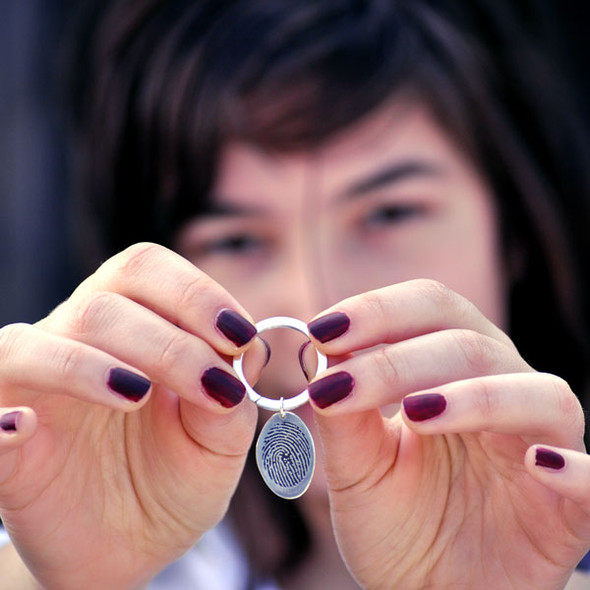 fingerprint key ring memorial in sterling silver held by a model