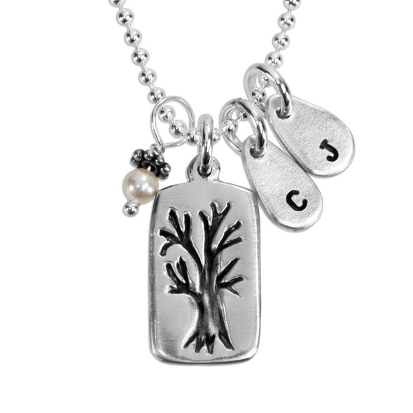 Custom fine silver Family Tree necklace, personalized with hand stamped kids' initials, hung with pearl charm, shown close up on white
