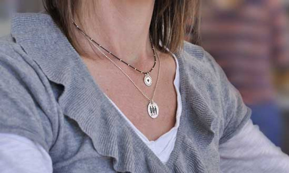 model wearing Dotted Border Sterling Silver Discs custom hand stamped with kids names and a heart
