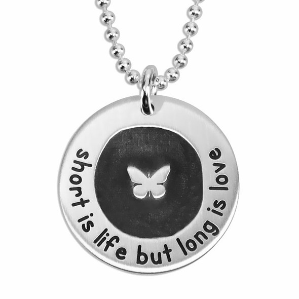 Custom silver etched butterfly circle necklace, personalized with hand stamped message on the back, shown close up on white