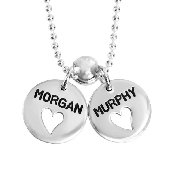Custom hand stamped Heart Cut-Out Silver Disc Necklace, personalized with kids' names, shown close up on white