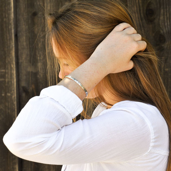 Personalized sterling silver Inspiration Cuff bracelet, hand stamped with your custom message or names, shown on a model