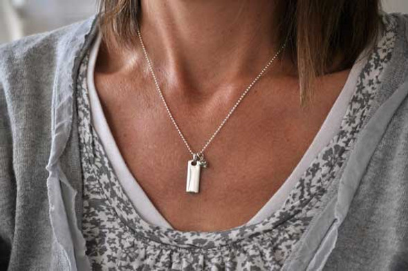Model wearing personalized hand stamped Rectangle Warmth Necklace, with the silver rectangle charm hung on a ball chain