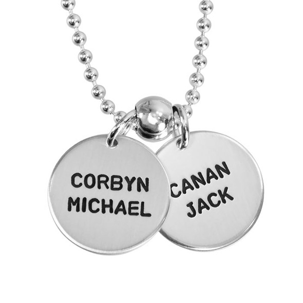 Kids' names custom stamped on silver mother's necklace with 5/8" discs, in block upper font, shown close up on white