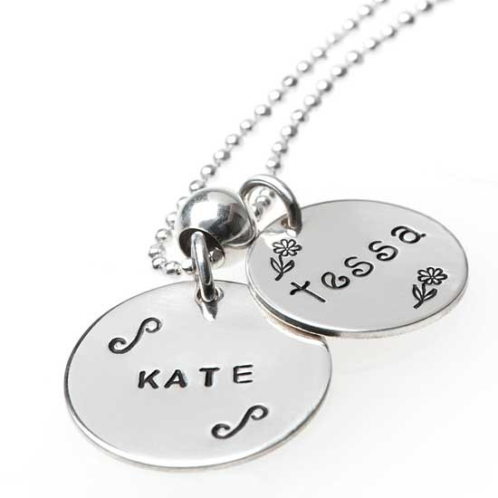 Our 3/4" and 5/8" sterling hand stamped name discs. "Kate" in Block Upper font on the 3/4" charm, and "tessa" in Lower Kissme font on the 5/8" charm