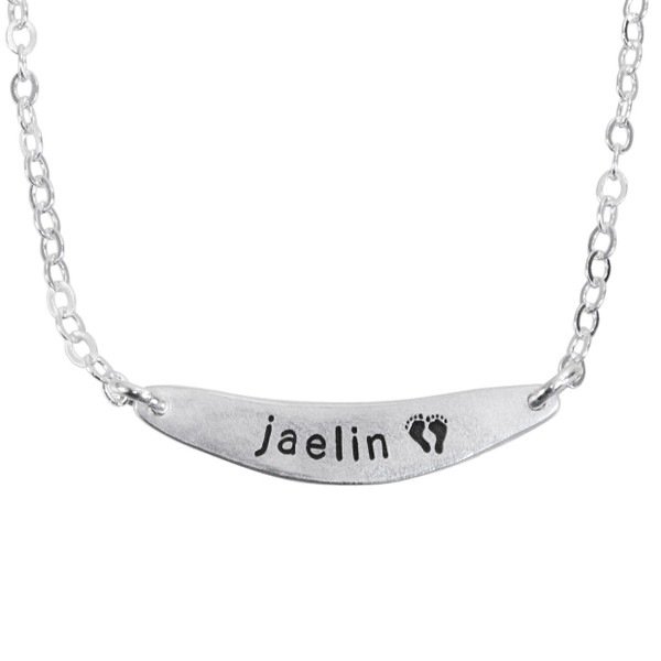 Custom fine silver arc charm, personalized with child's name stamped on the arc, shown close up on white