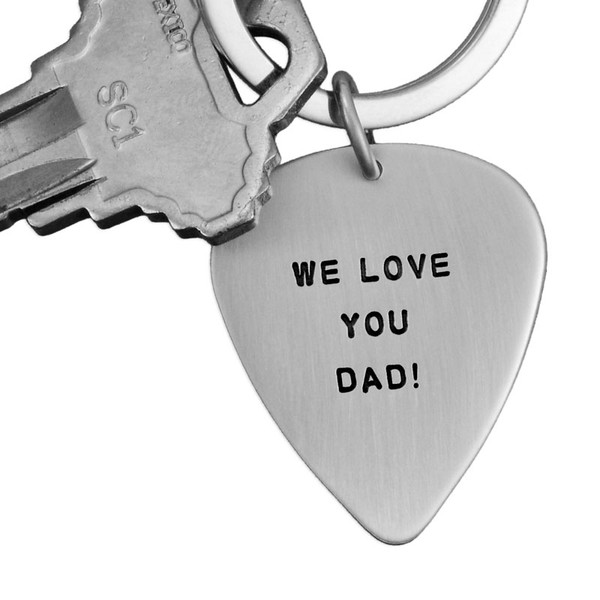 Father's Day gift of sterling silver hand stamped guitar pick key chain with message from the kids, shown with key on white background