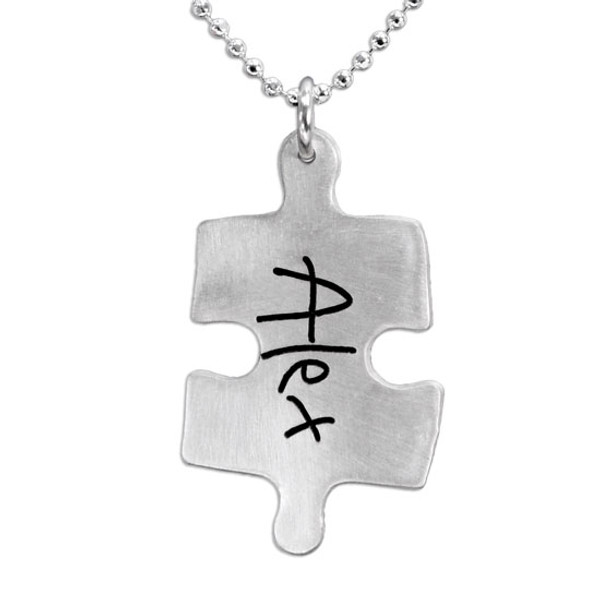 Silver Puzzle necklace with child's handwritten name, shown close up