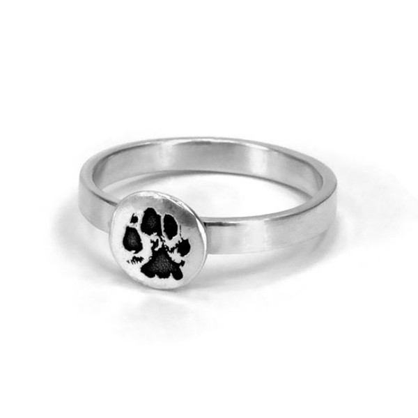 Custom silver paw print jewelry ring, personalized with your pet's actual pawprint, shown close up on white