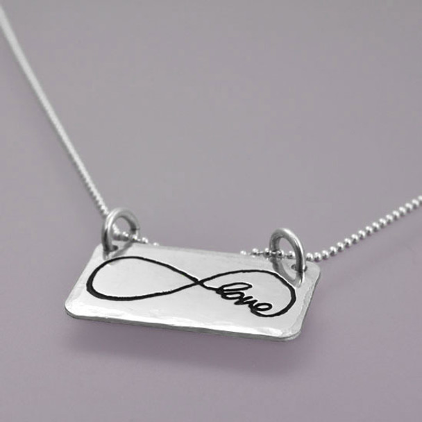 Side view of sterling silver rectangle jewelry made from handwriting, with infinity loop and the word Love